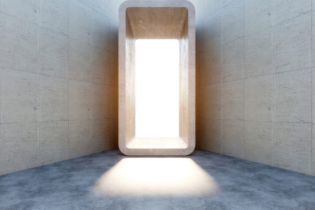 Sala minimalista com abertura retangular de luz intensa ao centro, paredes de pedra e piso cinzento polido.